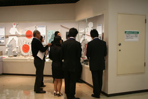 平塚市新採用職員研修「博物館で平塚を紹介しよう」で、展示解説ボランティアの会会員の説明を受ける新採用職員。