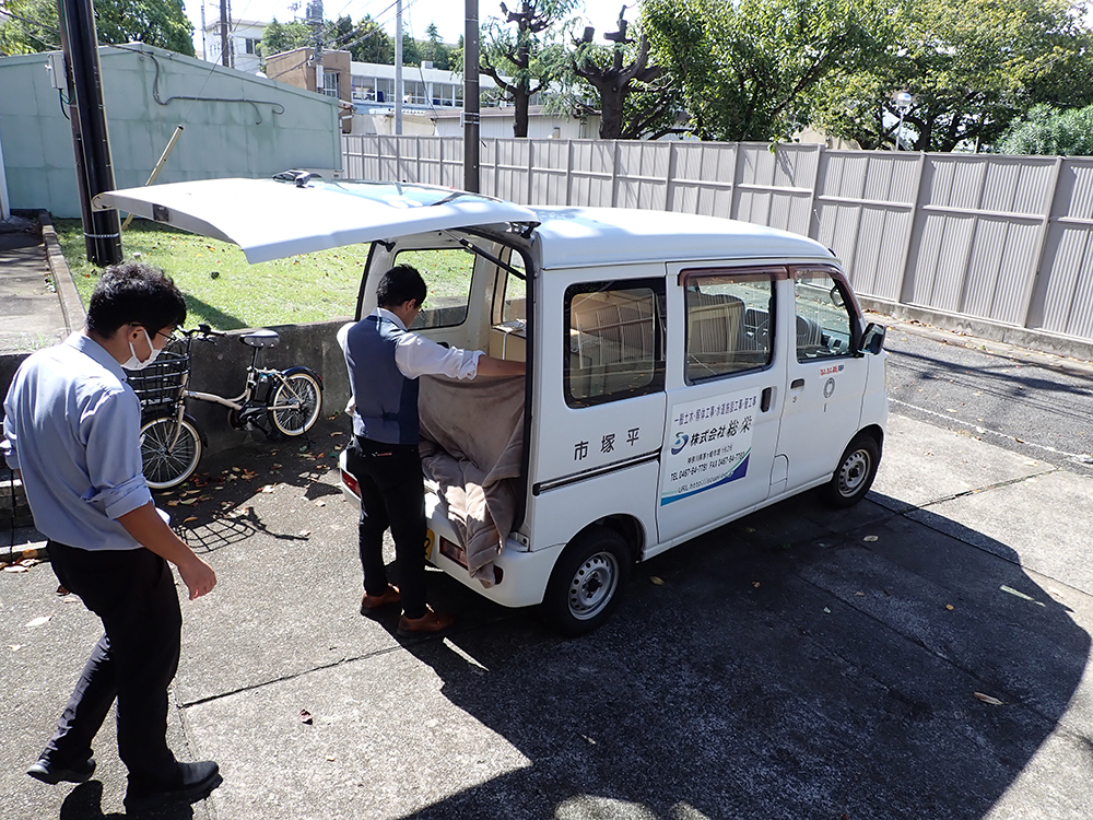 車に資料を積み込み、動かないように隙間を毛布で埋める様子。